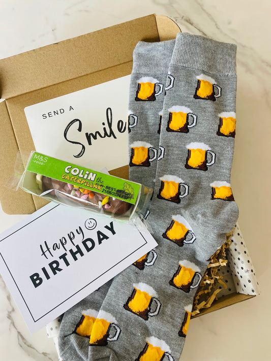 Birthday Gift Box, featuring, a mini Colin the Caterpillar birthday cake and fun beer socks. 