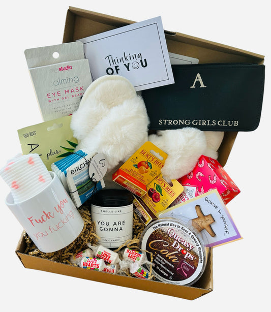 A care package gift box filled with numerous items and a heartfelt card, offering support for cancer patients. 